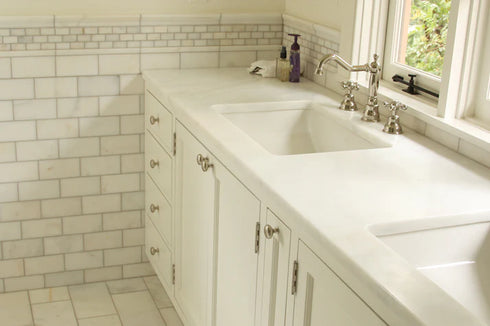 a bathroom with two sinks and a window