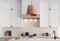 a kitchen with white cabinets and a copper light fixture